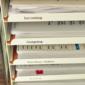 Organizador de documentos de oficina con bandejas identificadas como Incoming, Outgoing, Purchase Orders e Invoices.