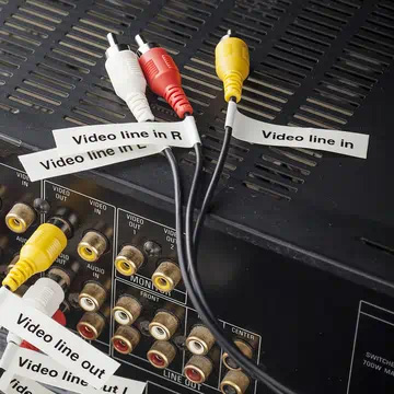 Panel posterior de un equipo audiovisual con diferentes cables identificados mediante etiquetas envolventes y tipo bandera.