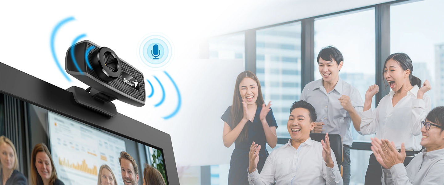 Webcam Genius FaceCam 1000X montada en la parte superior de un monitor mostrando en primer plano su micrófono incorporado activo y en segundo plano un grupo de personas de negocios celebrando durante una videoconferencia
