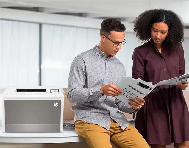 Impresora HP Color LaserJet Pro 4203dw en oficina con dos personas revisando documentos impresos