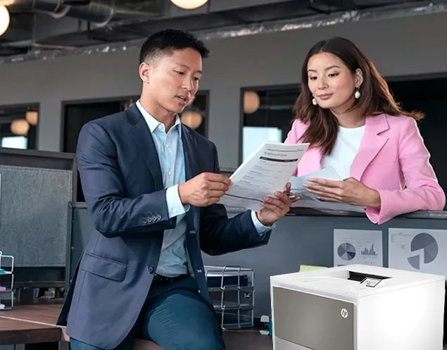 Impresora HP Color LaserJet Pro 4203dw en un entorno de oficina mientras dos colegas revisan impresiones de alta calidad