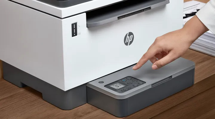 HP LaserJet Tank 2602sdw, primer plano de mano presionando el panel de control digital, mirá su diseño compacto.