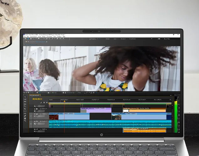 Primer plano de la pantalla de una laptop HP ProBook 440 G11. Muestra una aplicación de edición de video abierta con una línea de tiempo y un clip de dos mujeres en el monitor una de ellas sonriendo con el pelo al viento.