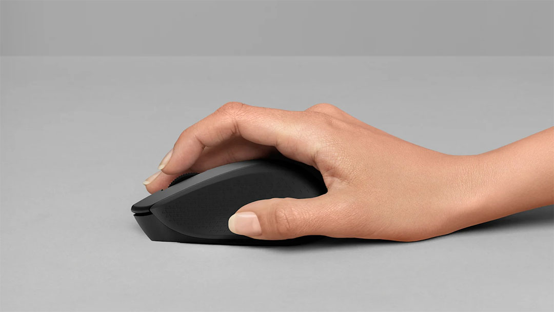 Mano usando un Mouse Inalámbrico Logitech M280 de color negro sobre una superficie gris.