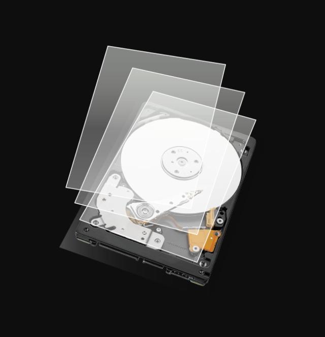 La imagen muestra un disco duro abierto con varias capas transparentes superpuestas. El disco duro tiene un plato blanco visible y componentes internos como el brazo lector y la placa base. Las capas transparentes parecen representar diferentes niveles o secciones del disco duro, proporcionando una vista detallada de su estructura interna.