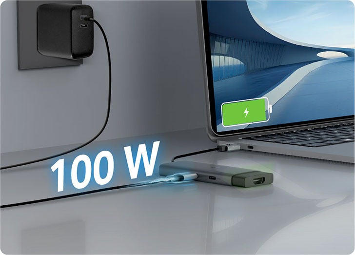 Notebook conectada a un Hub USB-C 5 en 1 TP-Link UH5020C que recibe carga rápida de 100W desde un enchufe, mostrando icono de batería cargando en la pantalla.
