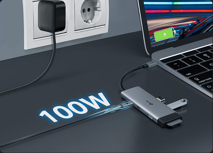 Notebook cargándose mediante adaptador TP-Link con entrega de potencia rápida de 100W desde una toma de corriente.