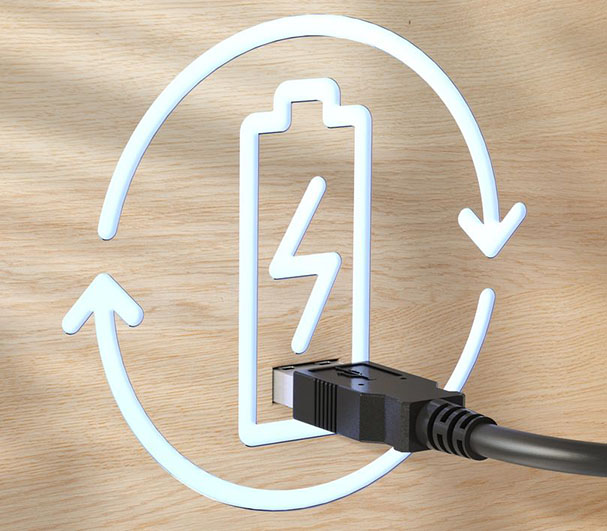 Icono de batería con signo de recarga y flechas circulares sobre fondo de madera, con un cable USB conectado a la parte inferior.