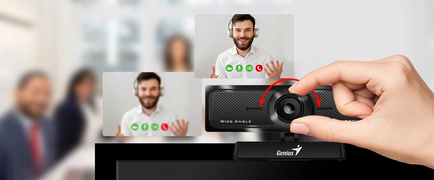 Mano girando el anillo de enfoque manual en la Genius WideCam F100 V2. El efecto de ajuste de foco se muestra en dos ventanas de videollamada de un hombre con barba y auriculares, con la imagen de la izquierda borrosa (desenfocada) y la de la derecha nítida (enfocada). Al fondo se ve una sala de reuniones borrosa.