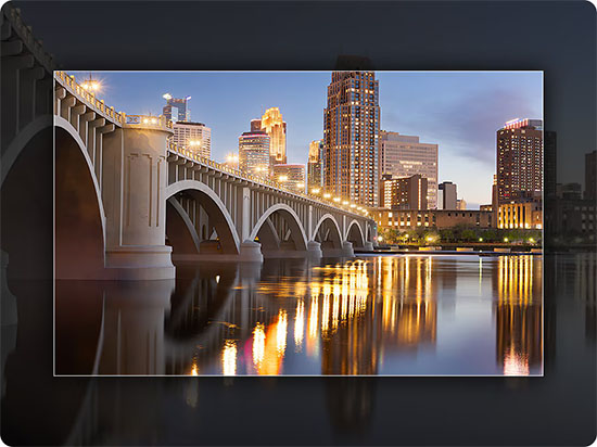 Comparación visual que muestra cómo la función Contrast Enhancer del televisor Crystal UHD ajusta dinámicamente el contraste en una escena nocturna de una ciudad con un puente, resaltando los detalles de las luces y dándole una mayor sensación de profundidad a la imagen para que la veas mucho más real.