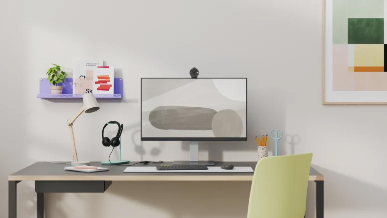 Escritorio minimalista con auriculares negros sobre base celeste, monitor y accesorios de oficina para vos