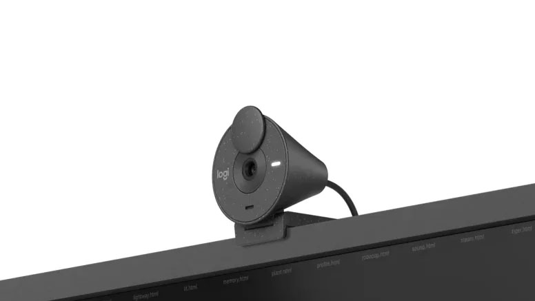 Primer plano de una webcam Logitech Brio 300 de color grafito colocada en la parte superior de un monitor.