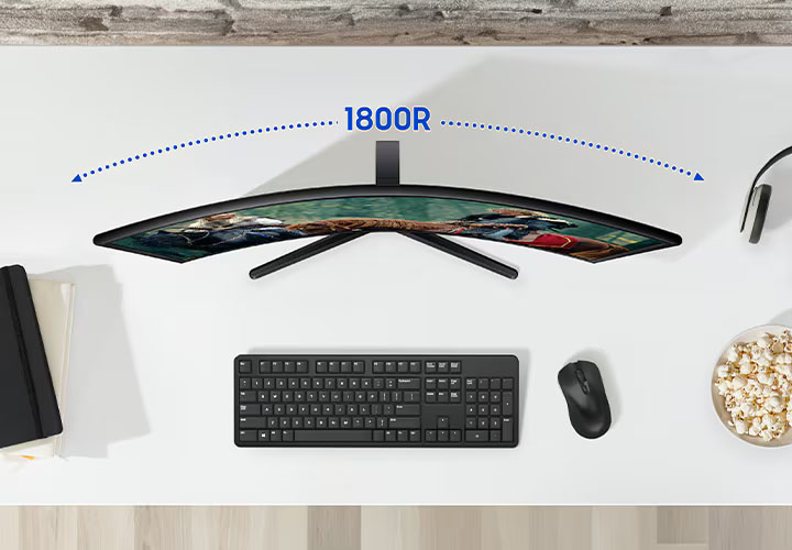 Sobre el escritorio hay un monitor y a su alrededor algunos periféricos. Encima del monitor está marcada su curvatura - 1800R.