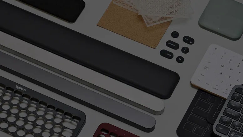 Accesorios y componentes Logitech organizados en un escritorio, incluyendo reposamuñecas, teclados numéricos y botones intercambiables