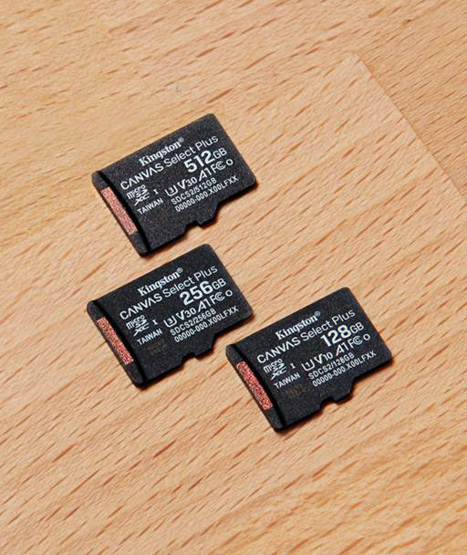 Un SSD NV3 NVMe M.2 está de pie en el borde del escritorio, con manos sobre un teclado en el fondo.