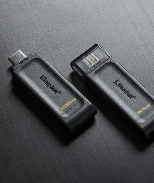 Un par de unidades flash USB DT70 puestas sobre una superficie textil