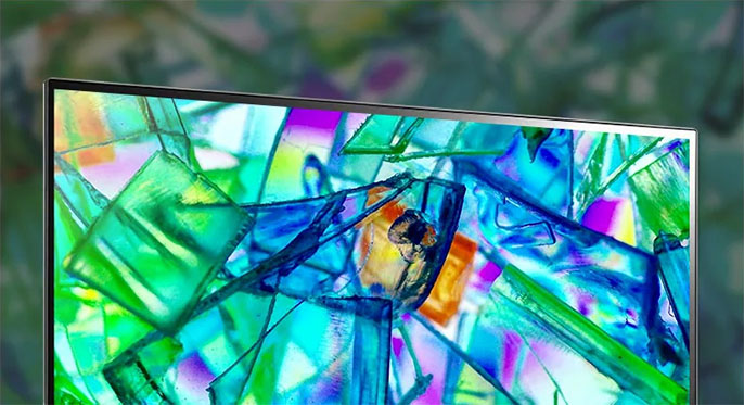 Primer plano de la esquina de un monitor mostrando una imagen colorida de cristales abstractos en tonos verdes, azules y violetas, destacando la viveza y nitidez de la pantalla IPS.
