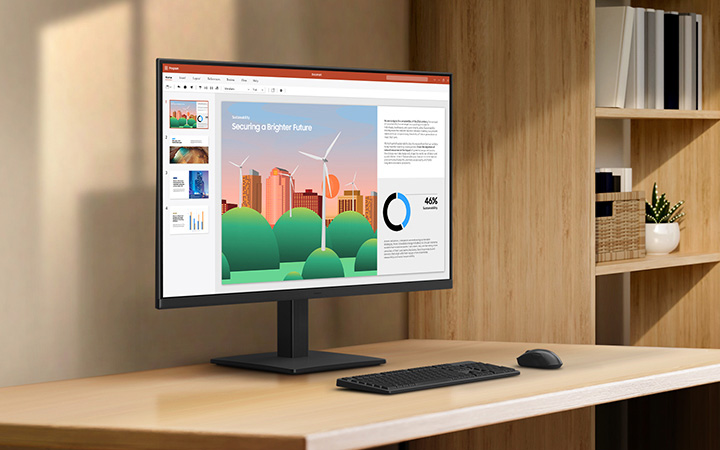 Monitor Samsung S3 S30GD sobre un escritorio de madera mostrando una presentación, con teclado y mouse enfrente, en una oficina hogareña con estanterías y decoración minimalista