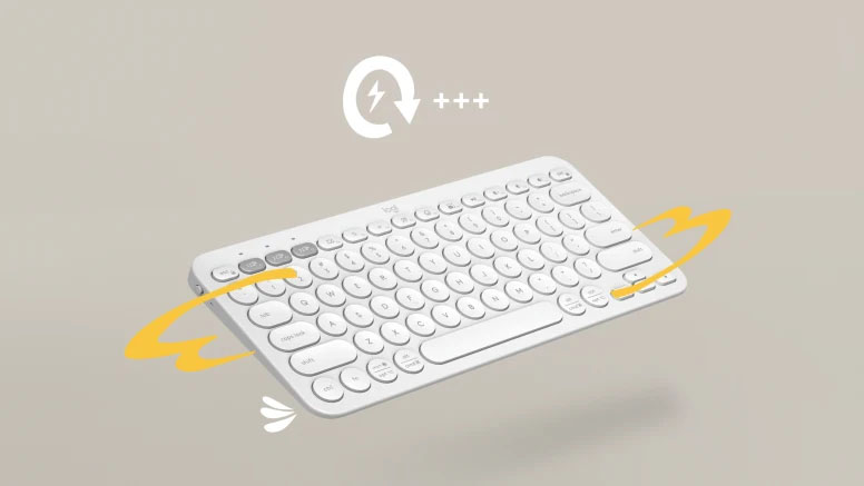 Un teclado Logitech Pebble Keys 2 K380s blanco en el aire, con un ícono de rayo y el texto +++ que indica su larga duración de batería.