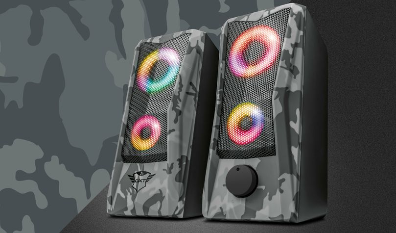 Parlantes 2.0 con iluminación RGB Trust GXT 606 Javv, diseño de camuflaje gris y negro, y control de volumen en la parte frontal.