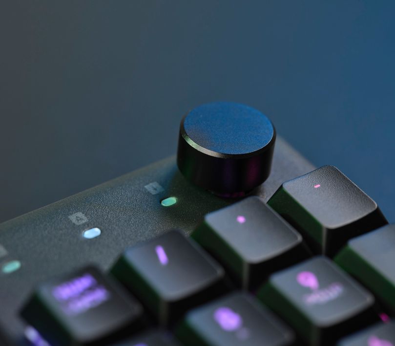 Primer plano de la perilla de volumen metálica del Teclado mecánico prémium Trust GXT 866 Torix