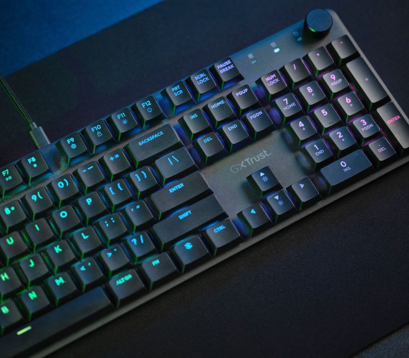 Teclado mecánico prémium Trust GXT 866 Torix, sobre un mousepad oscuro.