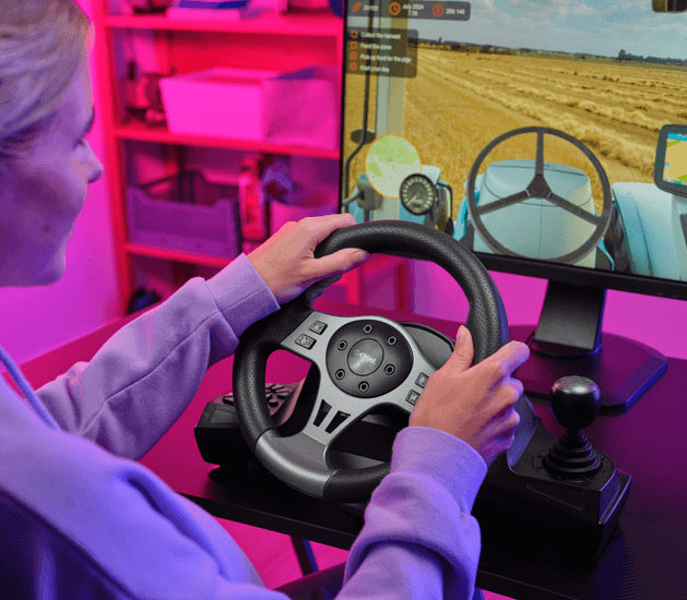 Chica joven usando el volante de carreras Trust GXT 289 Movi con palanca de cambios y pedales para jugar a un simulador de agricultura en su computadora, con iluminación ambiente violeta y rosa