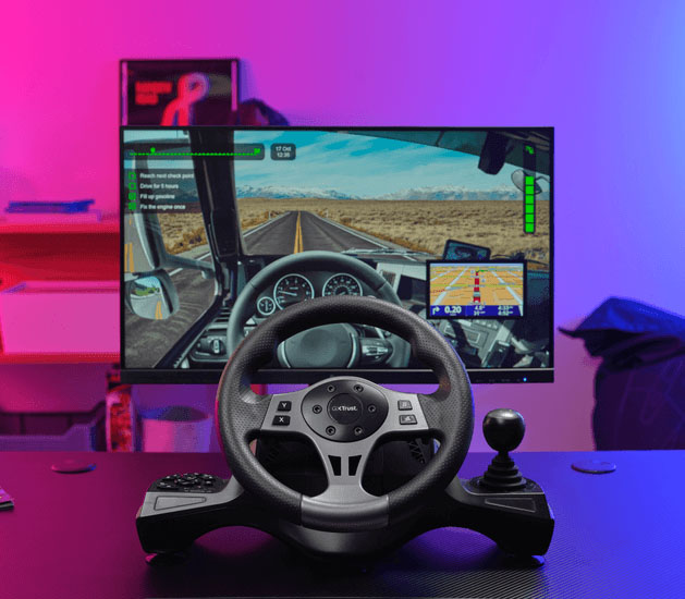 Volante de carreras Trust GXT 289 Movi con palanca de cambios y botones de control en primer plano sobre un escritorio de juego, con una pantalla de monitor mostrando un juego de manejo en la ruta de fondo y luces de ambiente violeta y azul