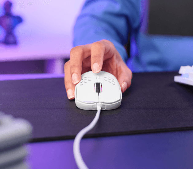 Mano usando el mouse gaming Trust GXT 928W Helox ultraliviano con cable sobre un mousepad gamer