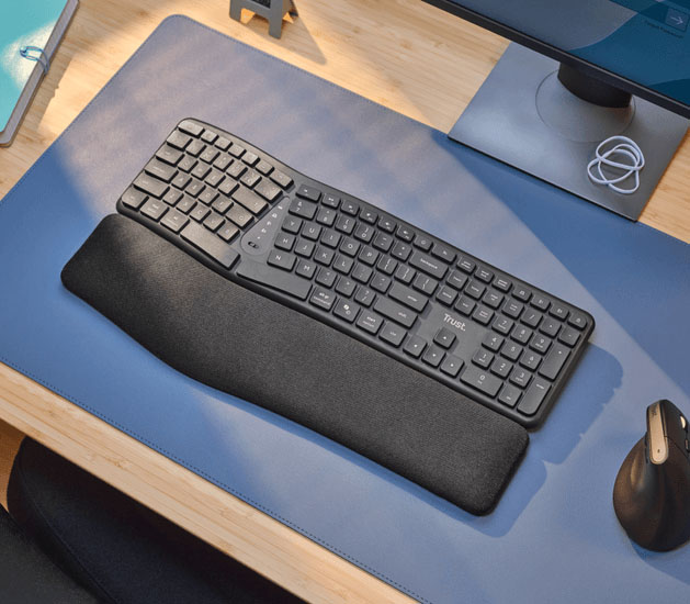 Vista superior del teclado inalámbrico ergonómico Trust Keyra con diseño dividido y reposamanos sobre un escritorio de oficina