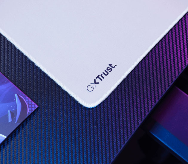 Detalle del mousepad Trust GXT con bordes cosidos y logo GXT Trust en la esquina