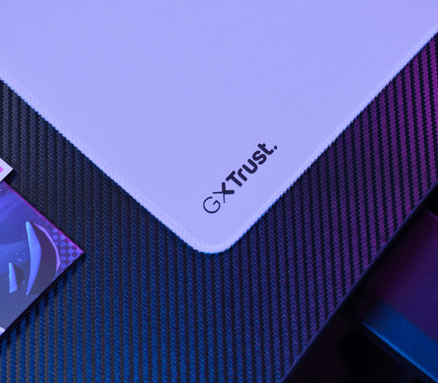 Detalle del mousepad Trust GXT con bordes cosidos y logo GXT Trust en la esquina