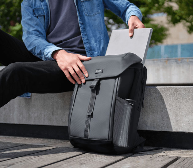 Persona guardando una notebook en la mochila Trust Jersey Travel Backpack negra con bolsillo lateral para botella
