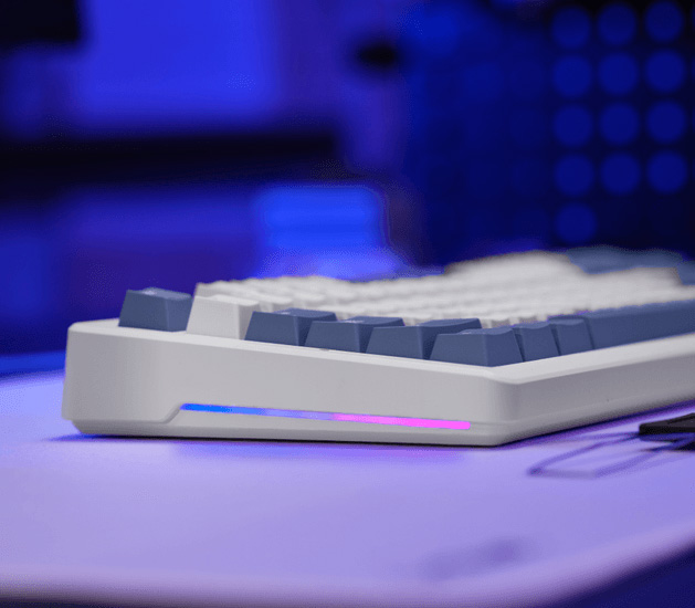Vista lateral del teclado Trust GXT 872 Xyra TKL con franja de iluminación RGB en la base y teclas blancas y grises