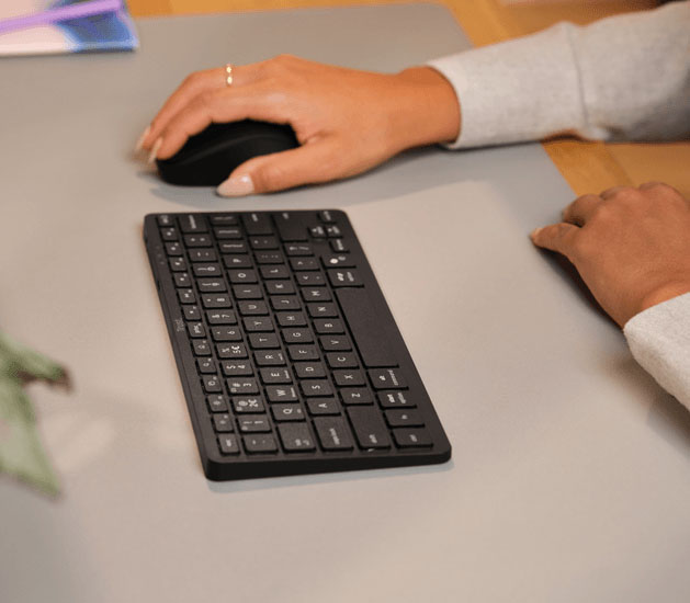 Teclado Trust Nado II Bluetooth compacto junto a un mouse sobre un escritorio