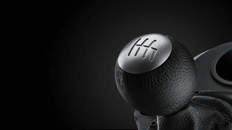 Detalle de la perilla de la palanca de cambios Logitech Driving Force™ Shifter forrada en cuero con el patrón en H para seis velocidades